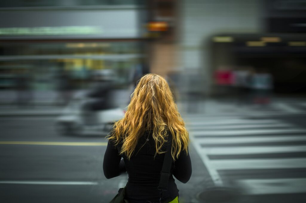 A woman gets ready to cross a street.