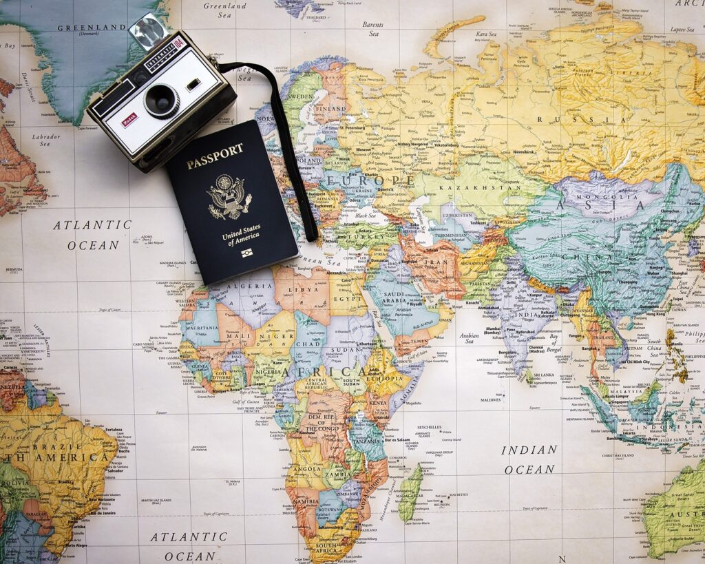 A camera and a passport on a map of the world. 