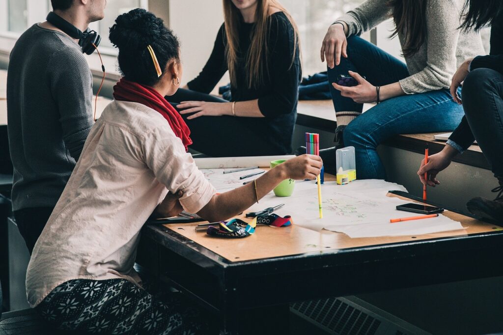 A group of people have a meeting to discuss recommended groups and resources for city girls.