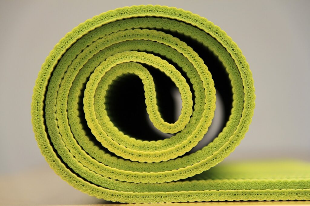 A rolled up green yoga matt for a city girl on a budget. 